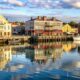 colorful waterfront buildings reflected calm water scaled